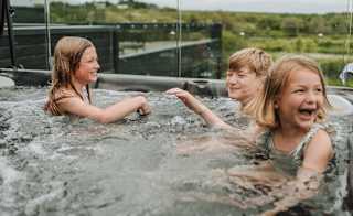 Three young children playing outside in one of our hot tubs at Retallack Resort & Spa. image
