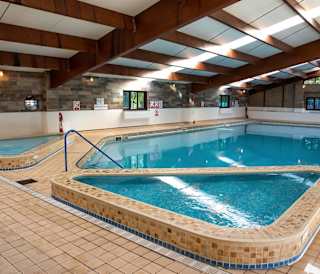 An image of a indoor swimming pool with clear blue water at one of our holiday parks.