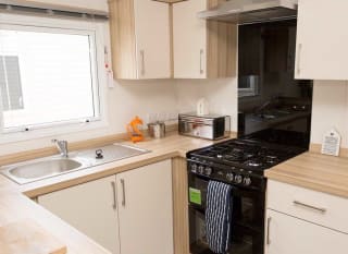 The kitchen area of our bright and spacious comfort static caravan. The perfect way to stay. image