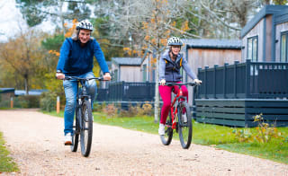 A happy couple cycling around our Sandy Balls Holiday Park located in the New Forest. image