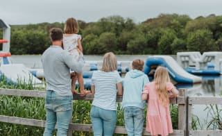 A young family looking over the watersports taking place on the lake at our stunning Retallack Resort & Spa. image