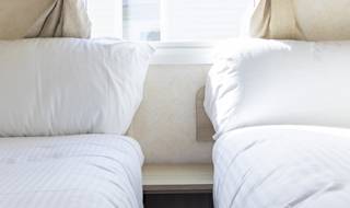 The twin bedroom of one of our budget-friendly value static caravans. The perfect way to stay. image