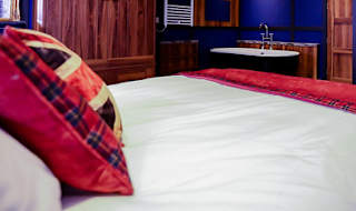 The master bedroom with bath tub at one of our exclusive accommodations, The Rockstar. Book your holiday now! image