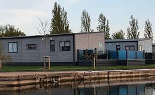 A view of our stunning holiday homes over the lake at Mill Rythe, Hampshire. image