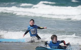 Two young boys enjoying their surf at Blue Surf School. image