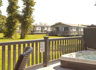 The decking with a hot tub of one of our stunning accommodations at St Helens Coastal Resort. image
