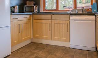 The interior of one of our Luxury holiday lodges. There's a kitchen area with many appliances, and an island in the centre. image
