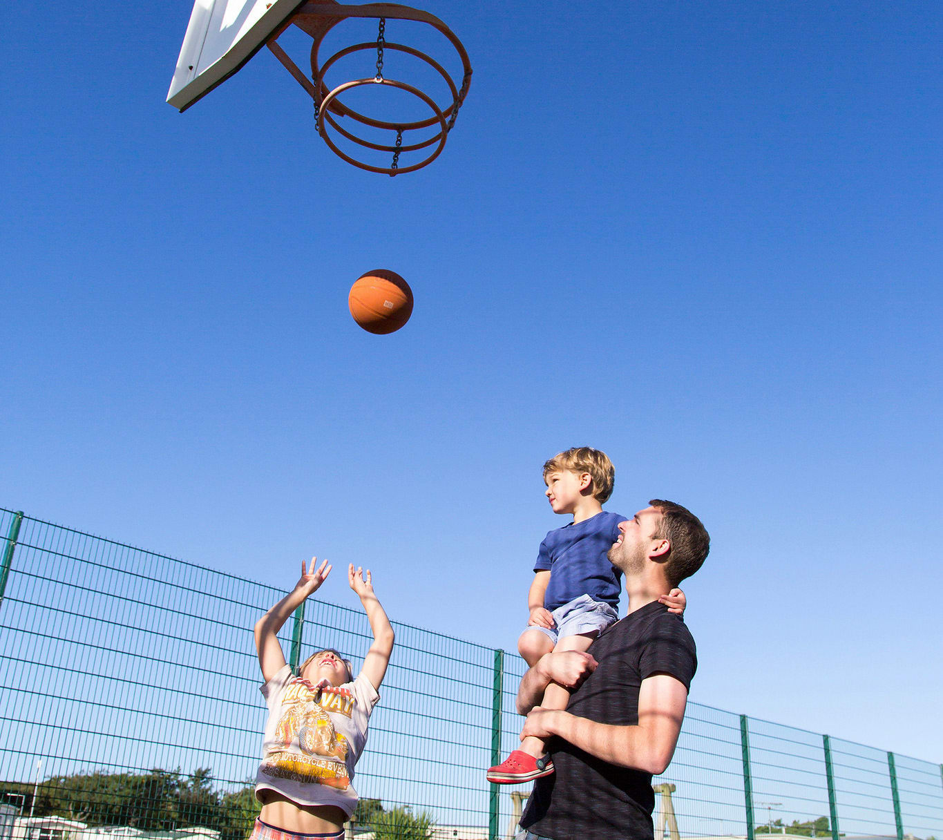 A family enjoying the outdoor sports court at our stunning park in North Wales, Barmouth Bay. image