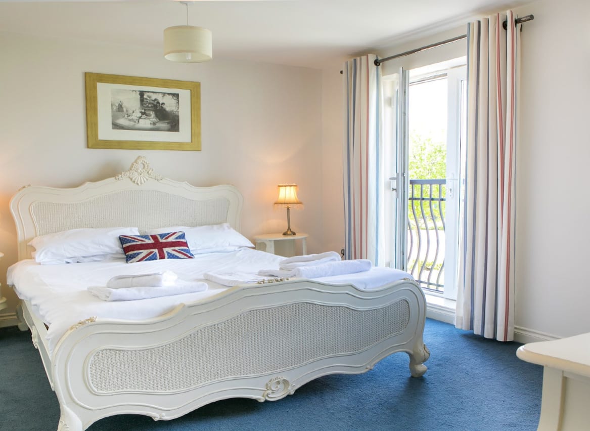 A double room in one of our apartments. Inside the room, a large bed can be seen, with access to a balcony area. image