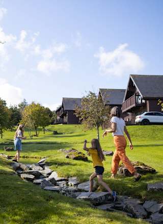 A woman and two young girls exploring the grounds of our holiday park. The are excitedly walking up a stone path.