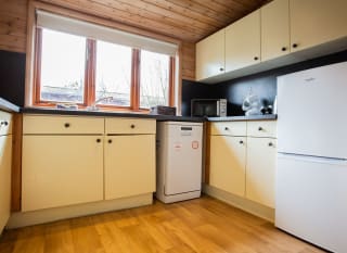 The interior of one of our woodland style holiday lodges. There's a spacious kitchen with various appliances. image