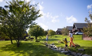 A woman and two young girls exploring the grounds of our holiday park. The are excitedly walking up a stone path. image