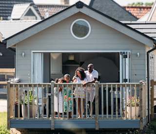 A family on the decking looking out onto the lake at our stunning resort, The Bay Filey.