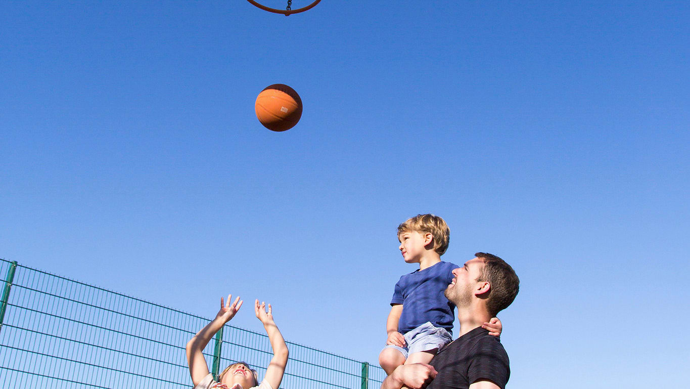 A family enjoying the outdoor sports court at our stunning park in North Wales, Barmouth Bay.