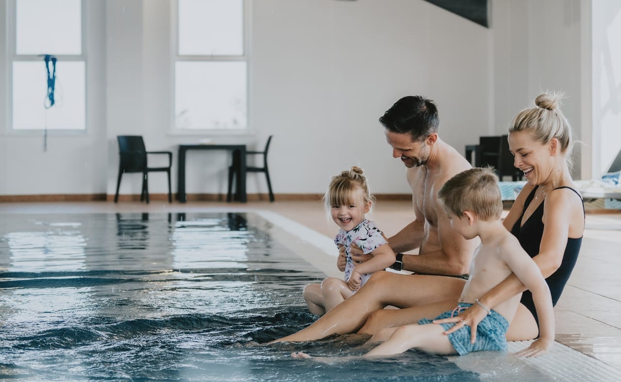 A young family playing in the indoor swimming pool at our holiday resort in Cornwall, Newperran. image