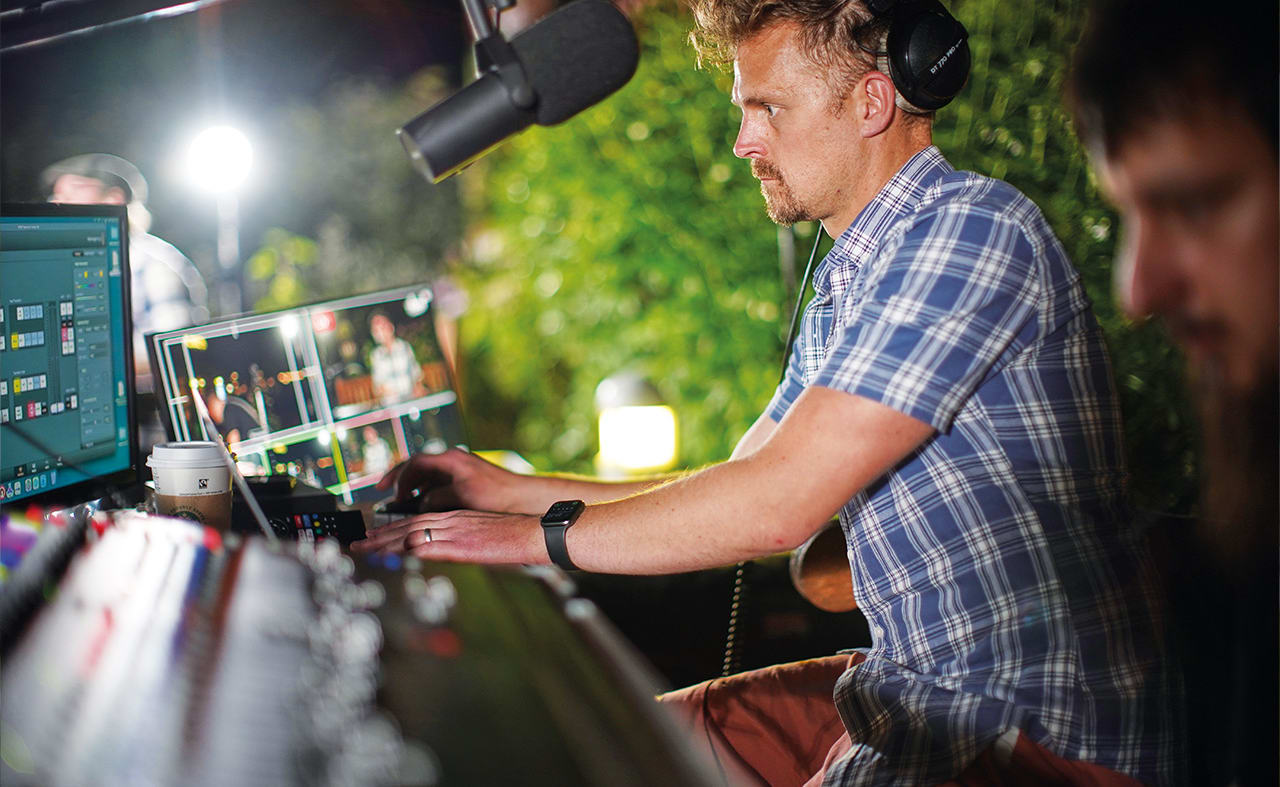 A male performing on a a set of DJ decks. image