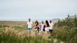 A family enjoying a peaceful stroll to the Cornish coastline on a summers day.