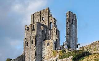 An image of Corfe Castle on a bright day with blue skies. image