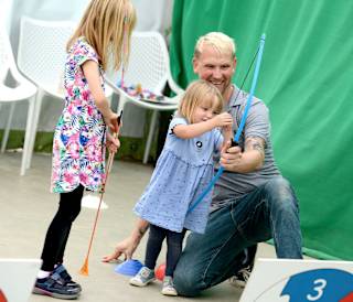 A family taking part in the Mini Archery activity.