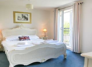 A double room in one of our apartments. Inside the room, a large bed can be seen, with access to a balcony area. image
