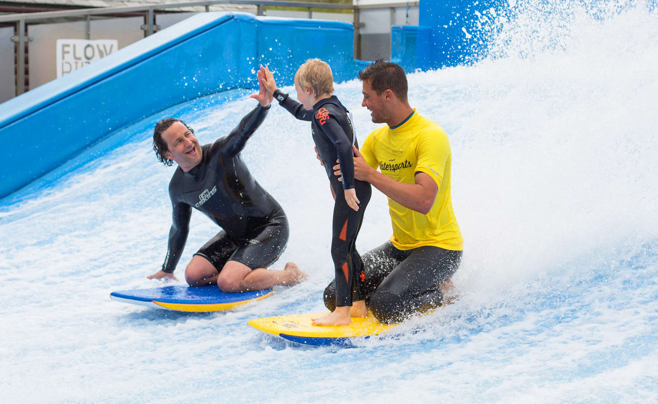 A family enjoying a surf on the Flowrider at our Cornish Resort, Retallack Resort & Spa. image