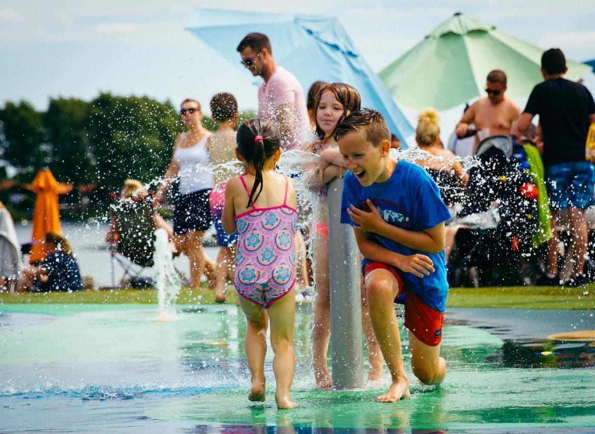 Young children playing in our outdoor splash pad. image
