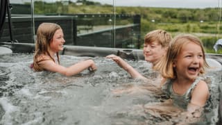 Three young children playing outside in one of our hot tubs at Retallack Resort & Spa.