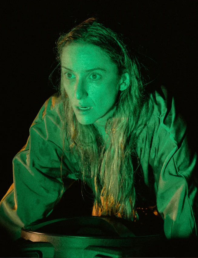 ATRIZ de perfil segurando um casaco com luz esverdeada sobre ela