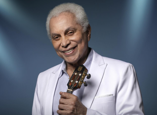 cantor negro de cabelo branco com violão