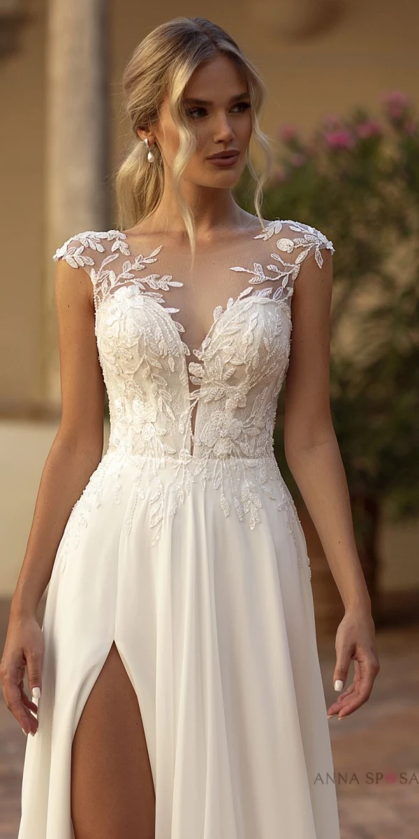 Robe de mariée Tina avec un bustier en dentelle illusion et une jupe fluide fendue, idéale pour une mariée moderne et élégante.