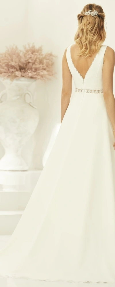 Robe de mariée Ally avec décolleté en V plongeant et ceinture perlée, élégante et minimaliste.