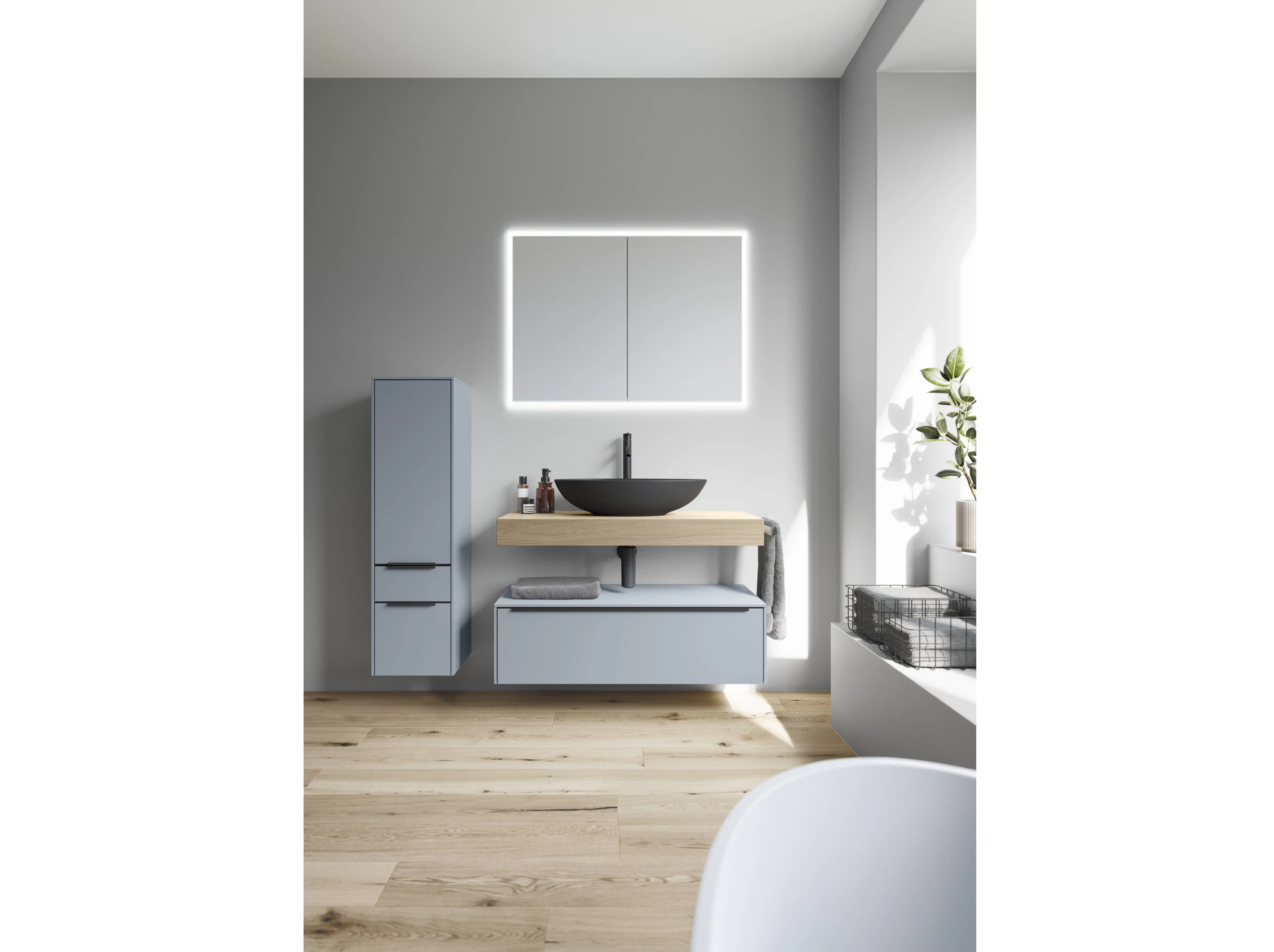 Hellblaues Badezimmer mit Holzwaschtisch und schwarzem Waschbecken, beleuchteter Spiegel