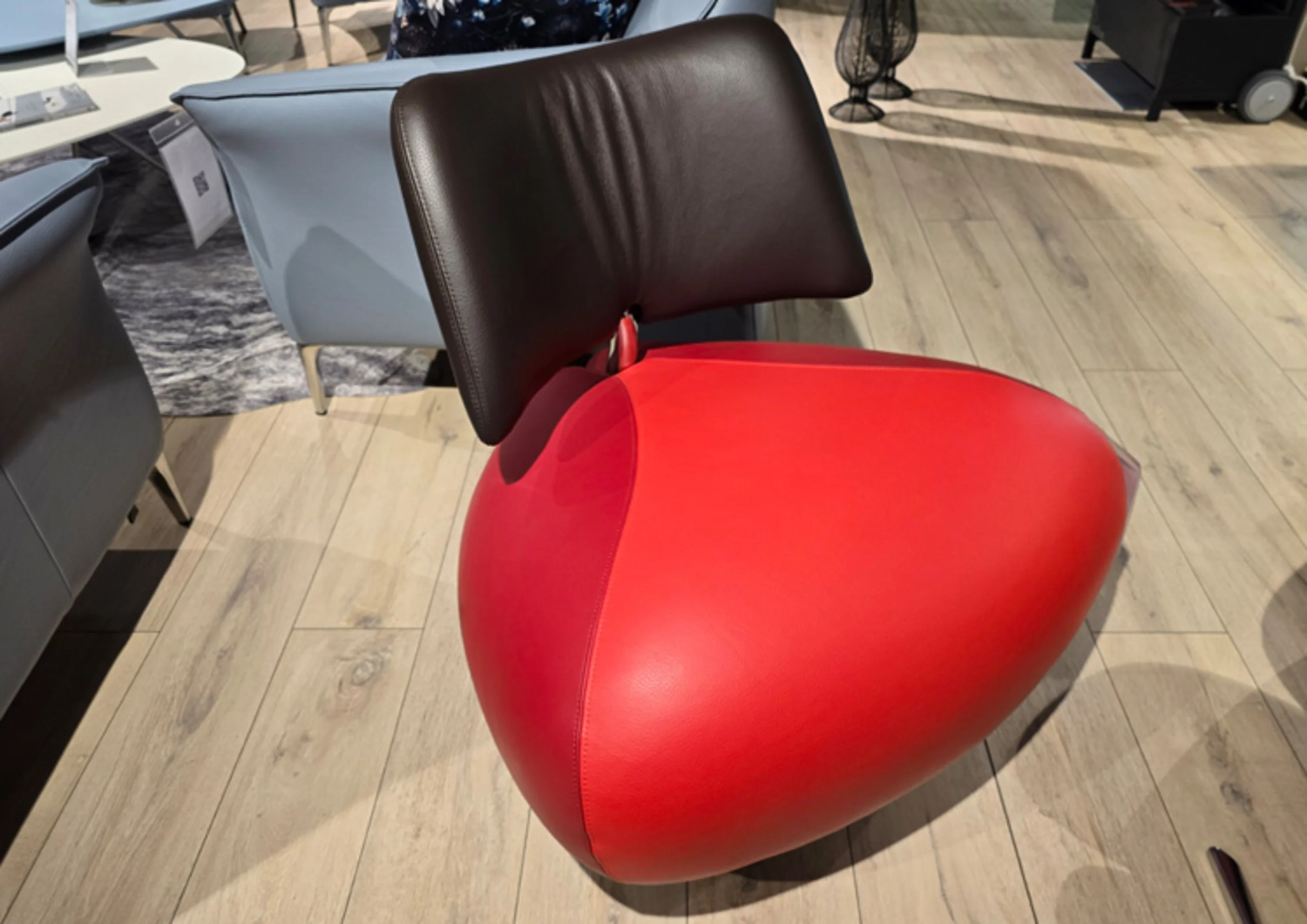 Dreieckiger Sessel mit rotem Sitz und braunem Rücken