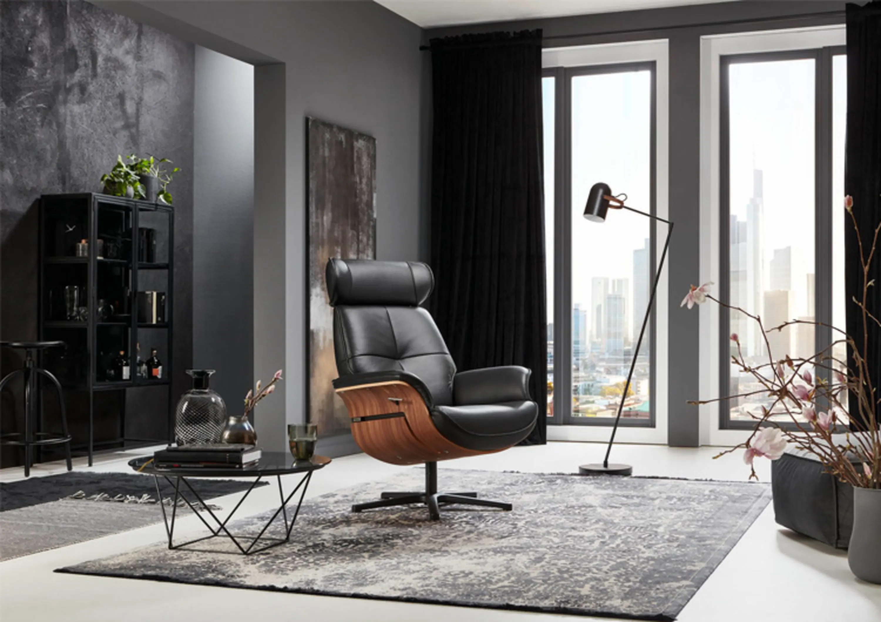 Schwarzer verstellbarerFernsehsessel mit Sitzschale in dunkler Holzoptik auf Drehkreuz in einem modernen Wohnzimmer