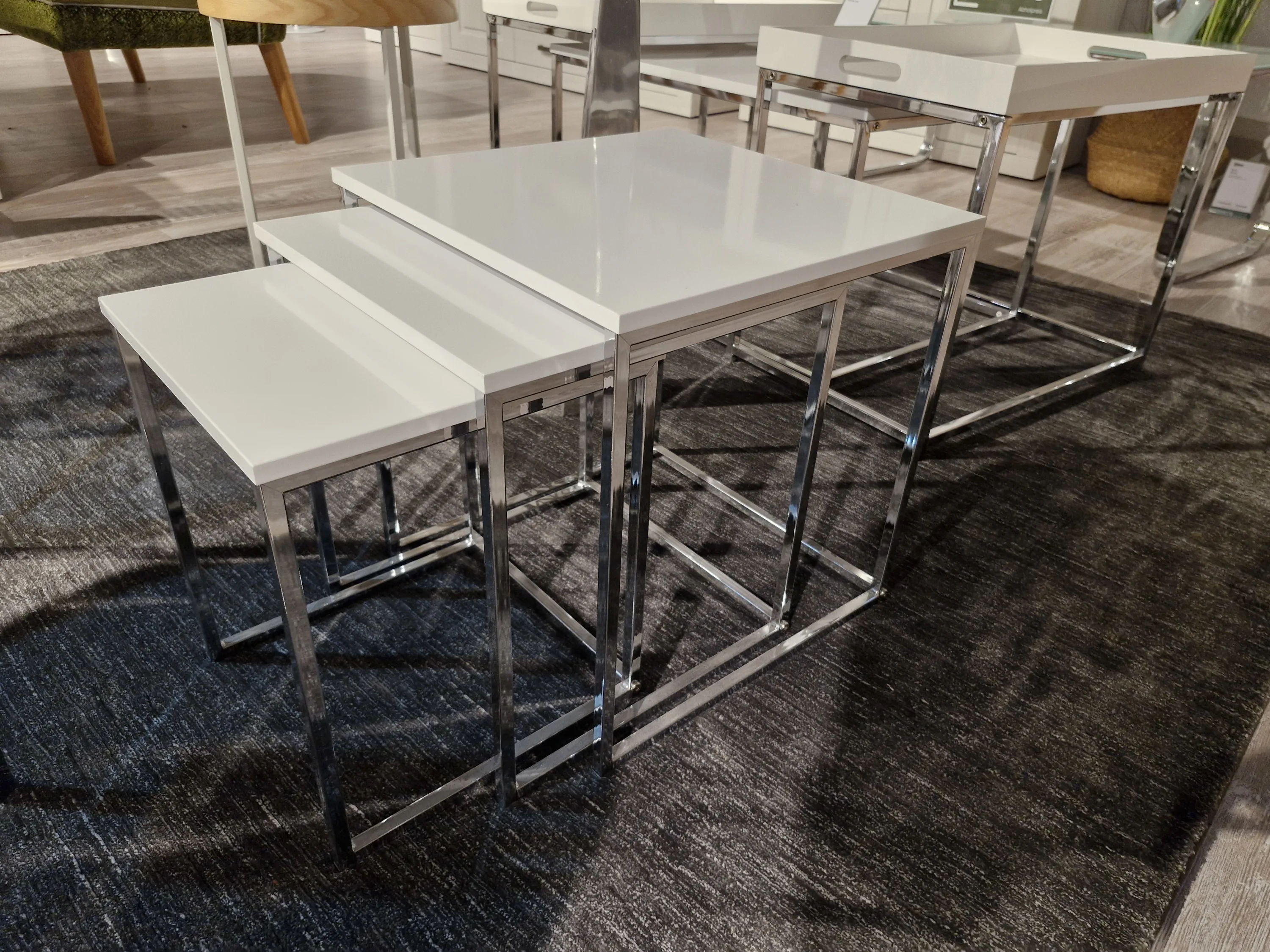 Weißer Tisch mit vier Stühlen und einem schwarzen Teppich