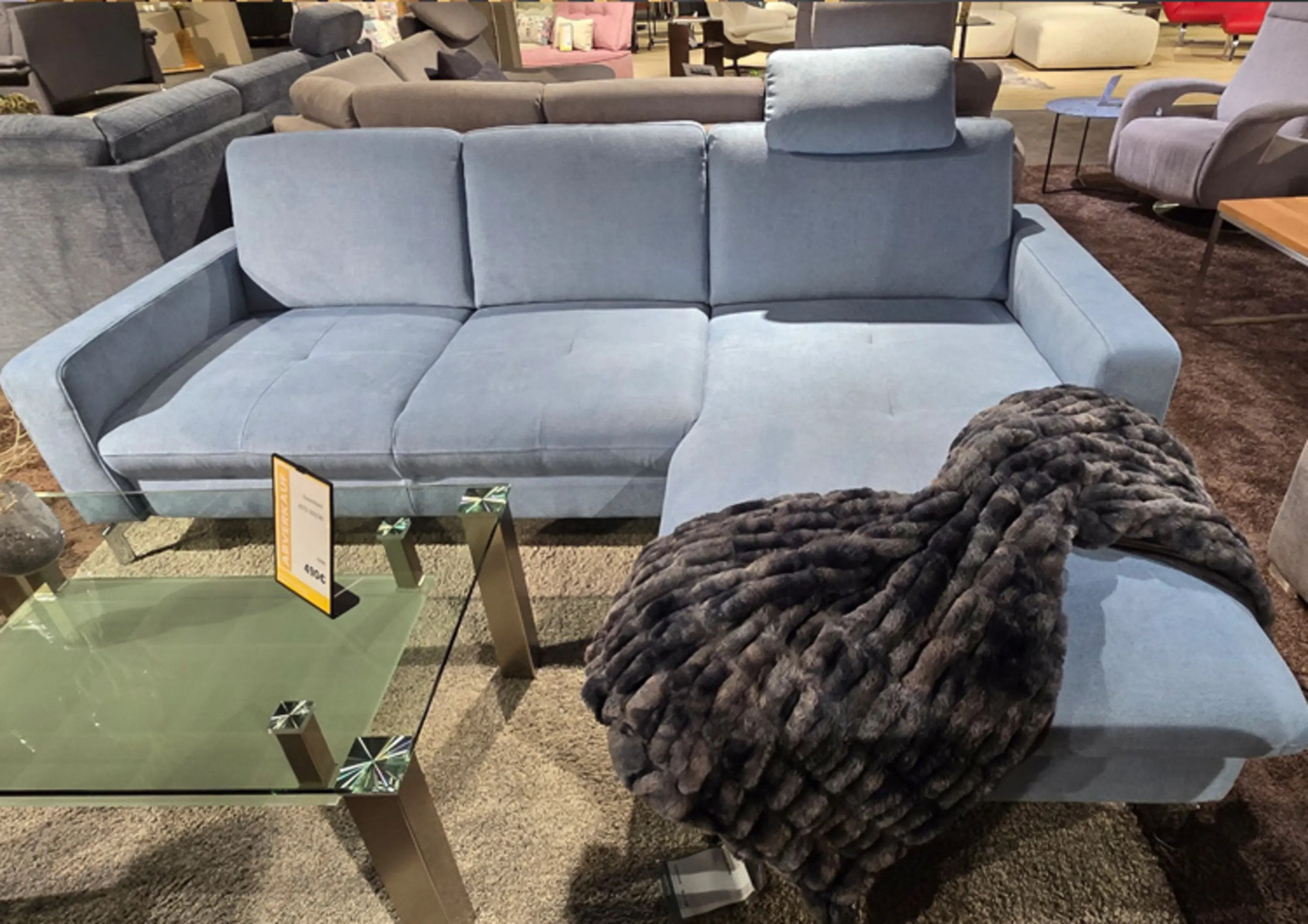 Modernes Ecksofa in elegantem Hellblau mit klaren Linien, einer Kopfstütze und großzügiger Recamiere für entspannten Sitz- und Liegekomfort.