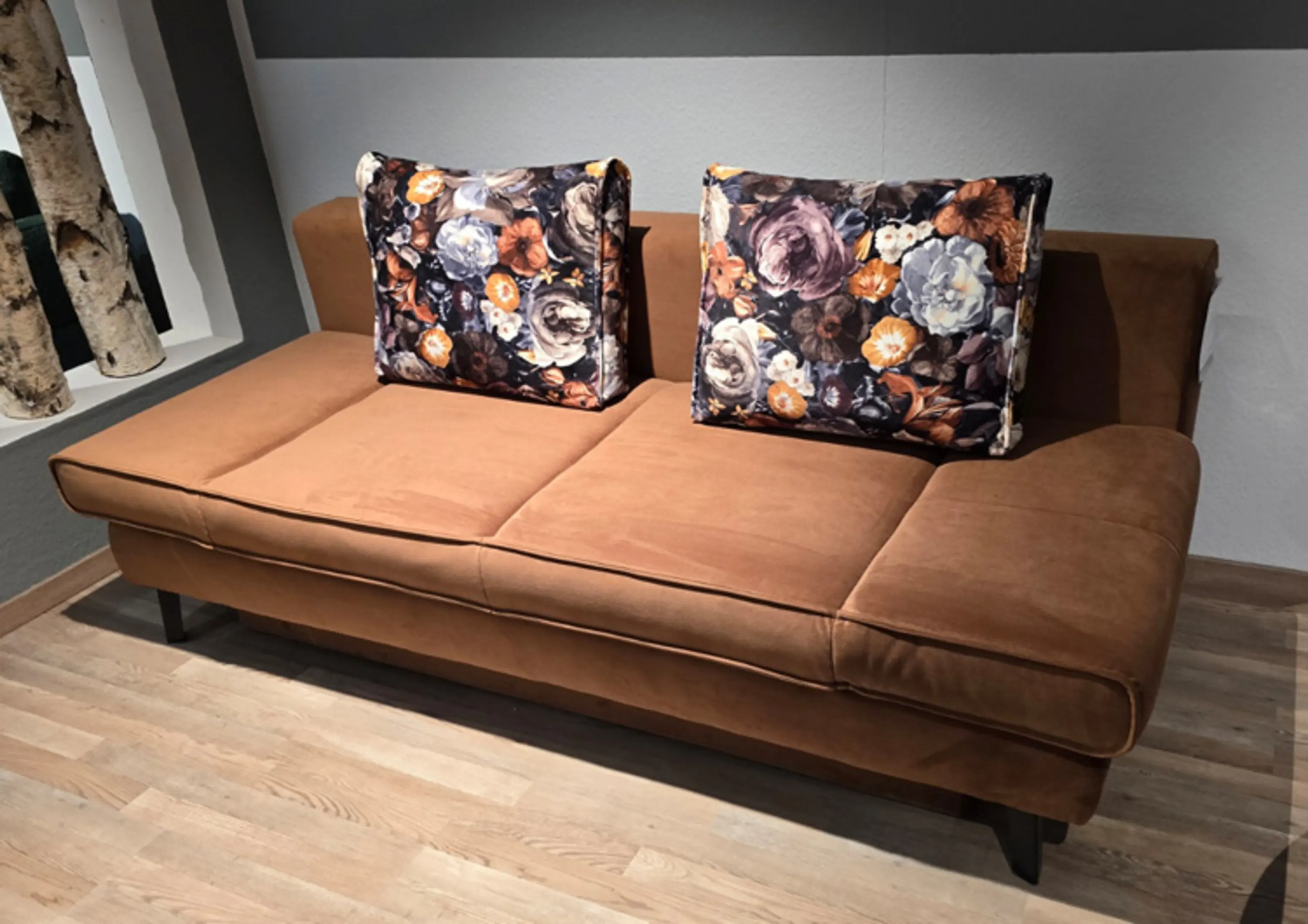 Braunes Schlafsofa mit zwei Kissen mit Blumenmuster