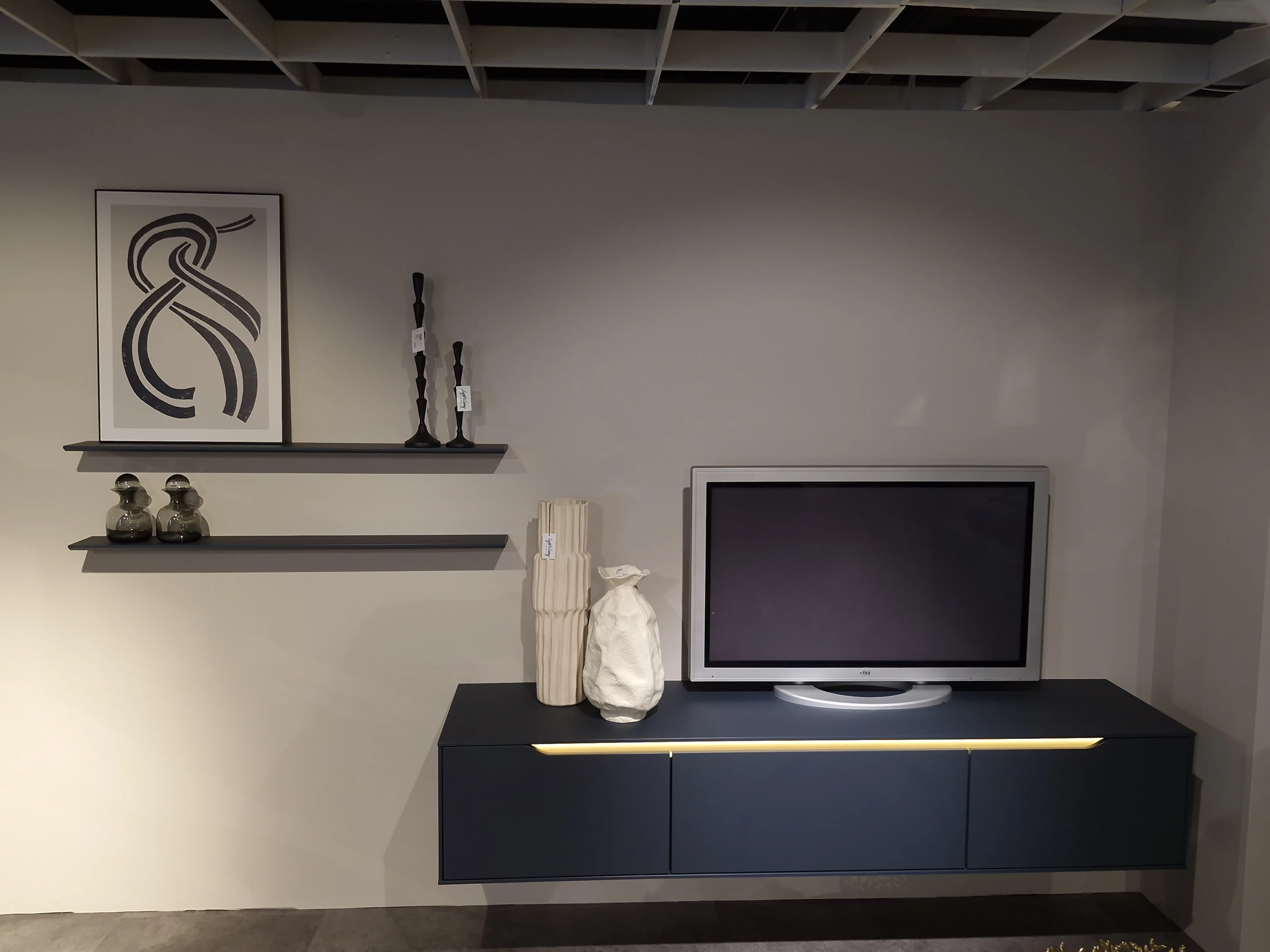 Fernseher an der Wand mit dem Regal darüber