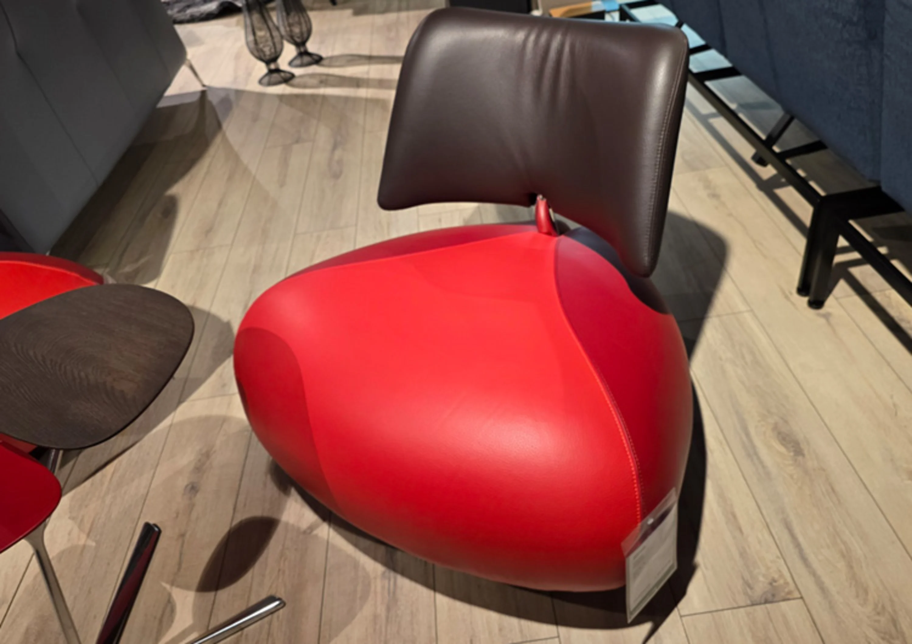 Dreieckiger Sessel mit rotem Sitz und braunem Rücken