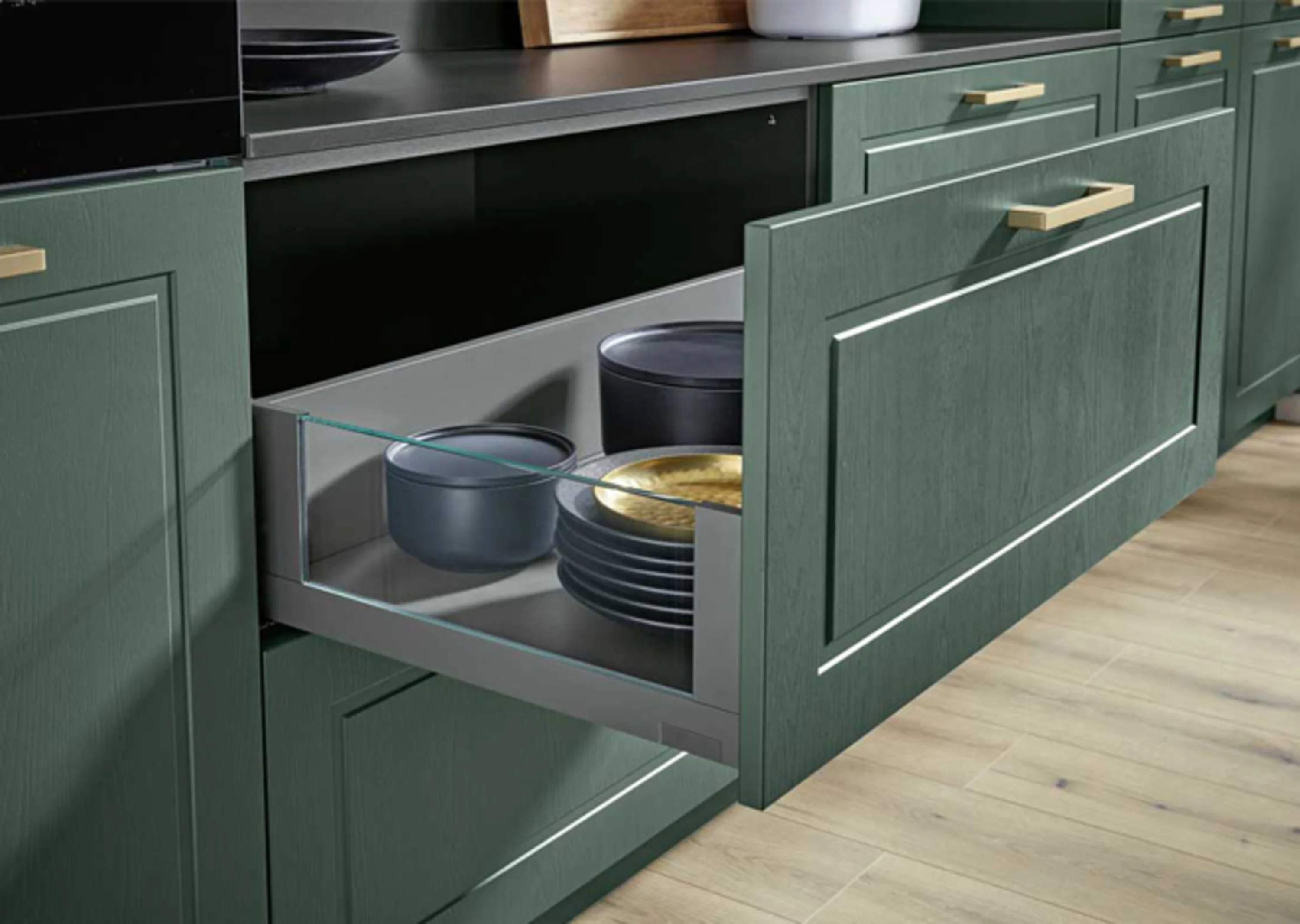 Küche mit grünen Schränken und einem schwarzen Herd