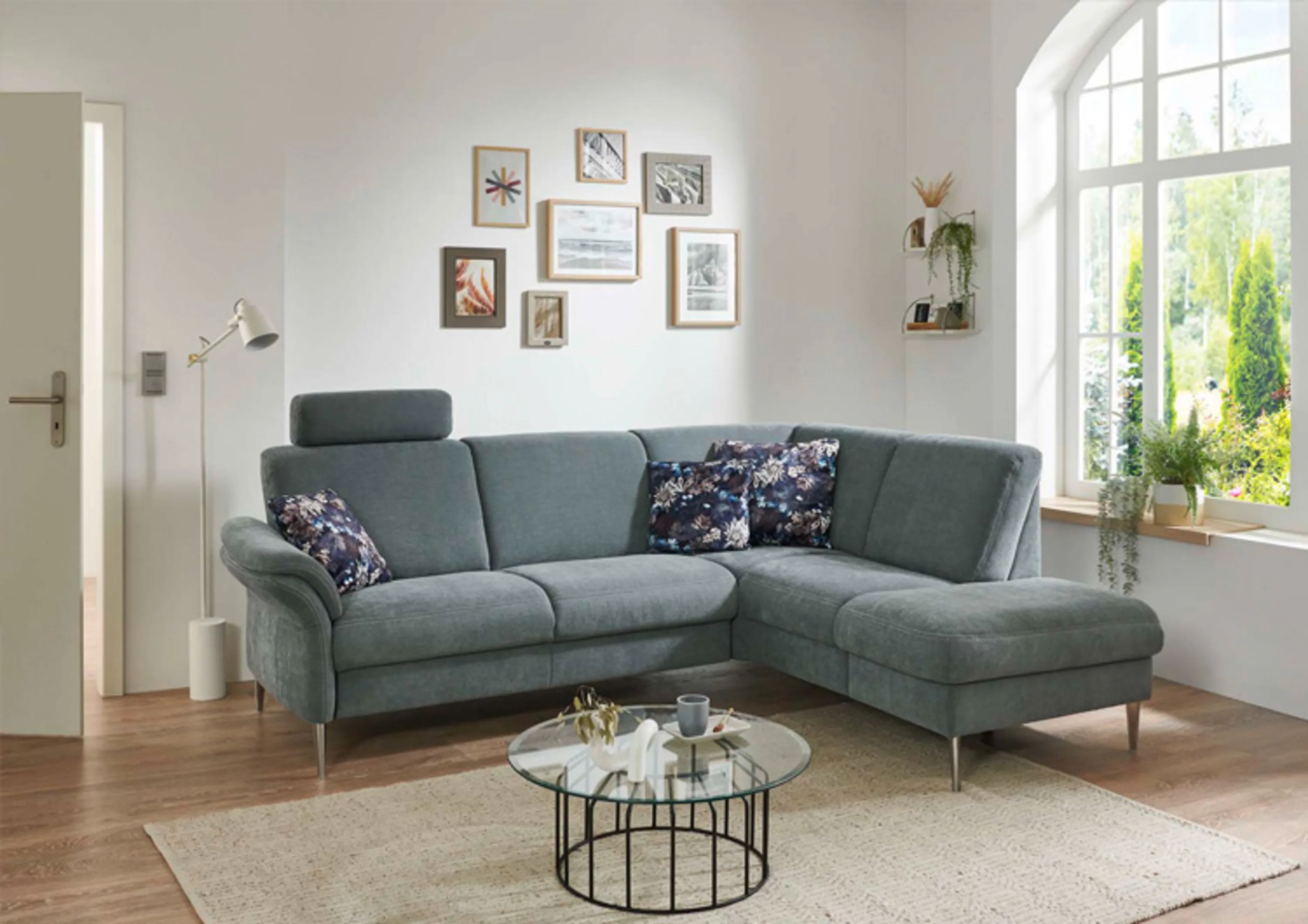 Graues Sofa mit einem blauen und weißen Blumenkissen