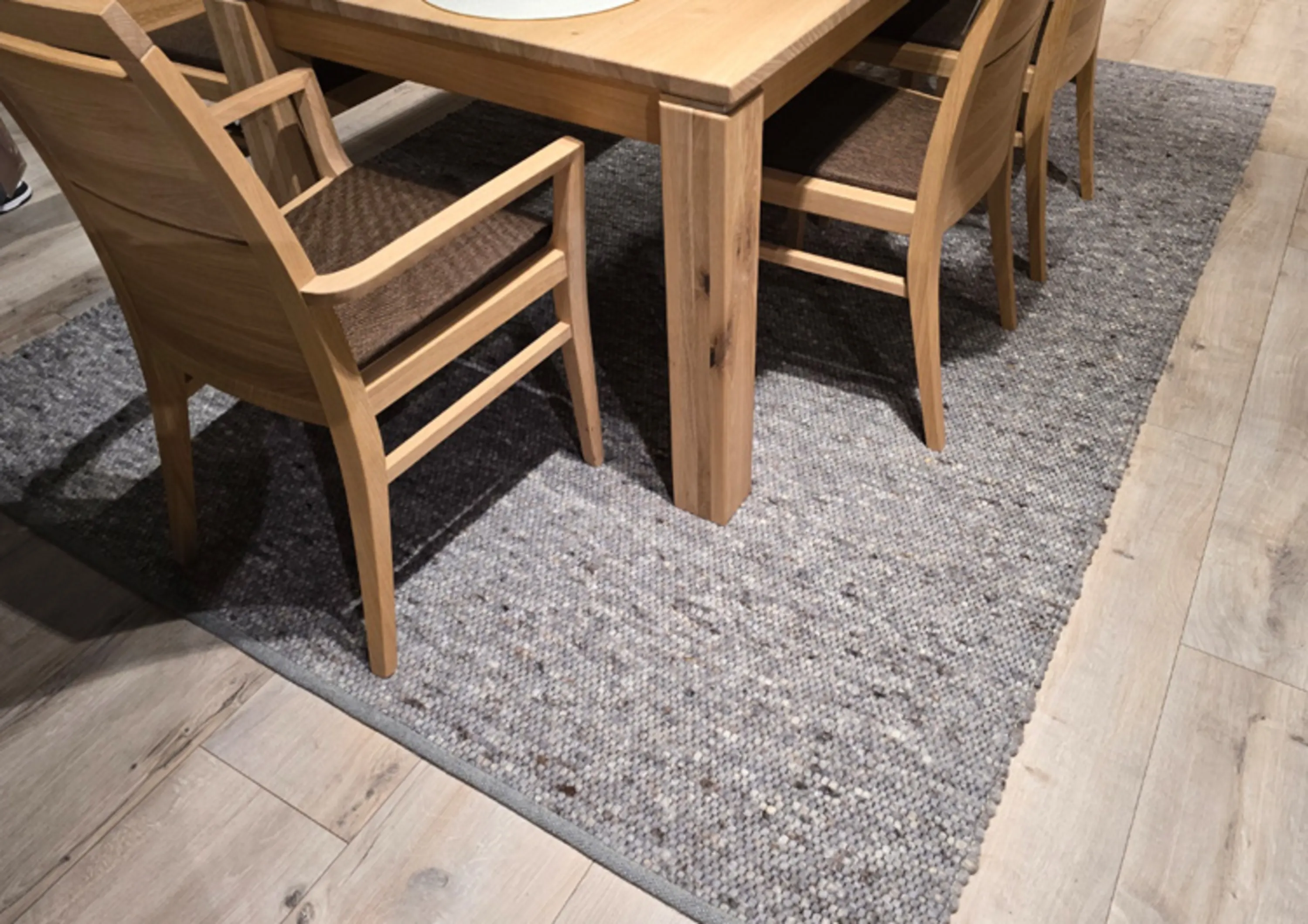Grauer Teppich unter Tischgruppe