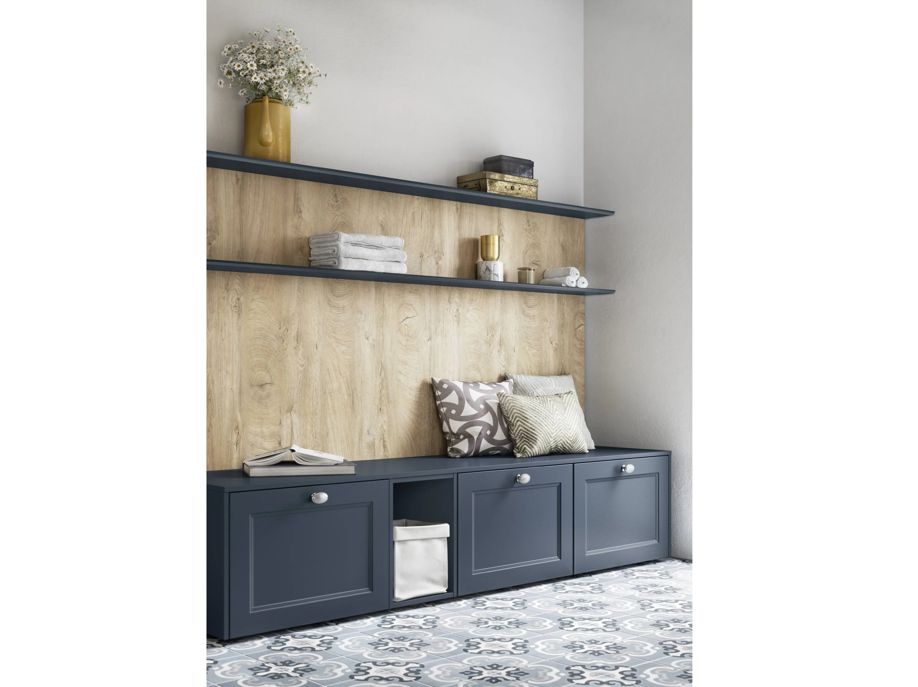 Badezimmereinrichtung aus blauen Schränken in Bankform, Regalen und Holzplatte im Hintergrund
