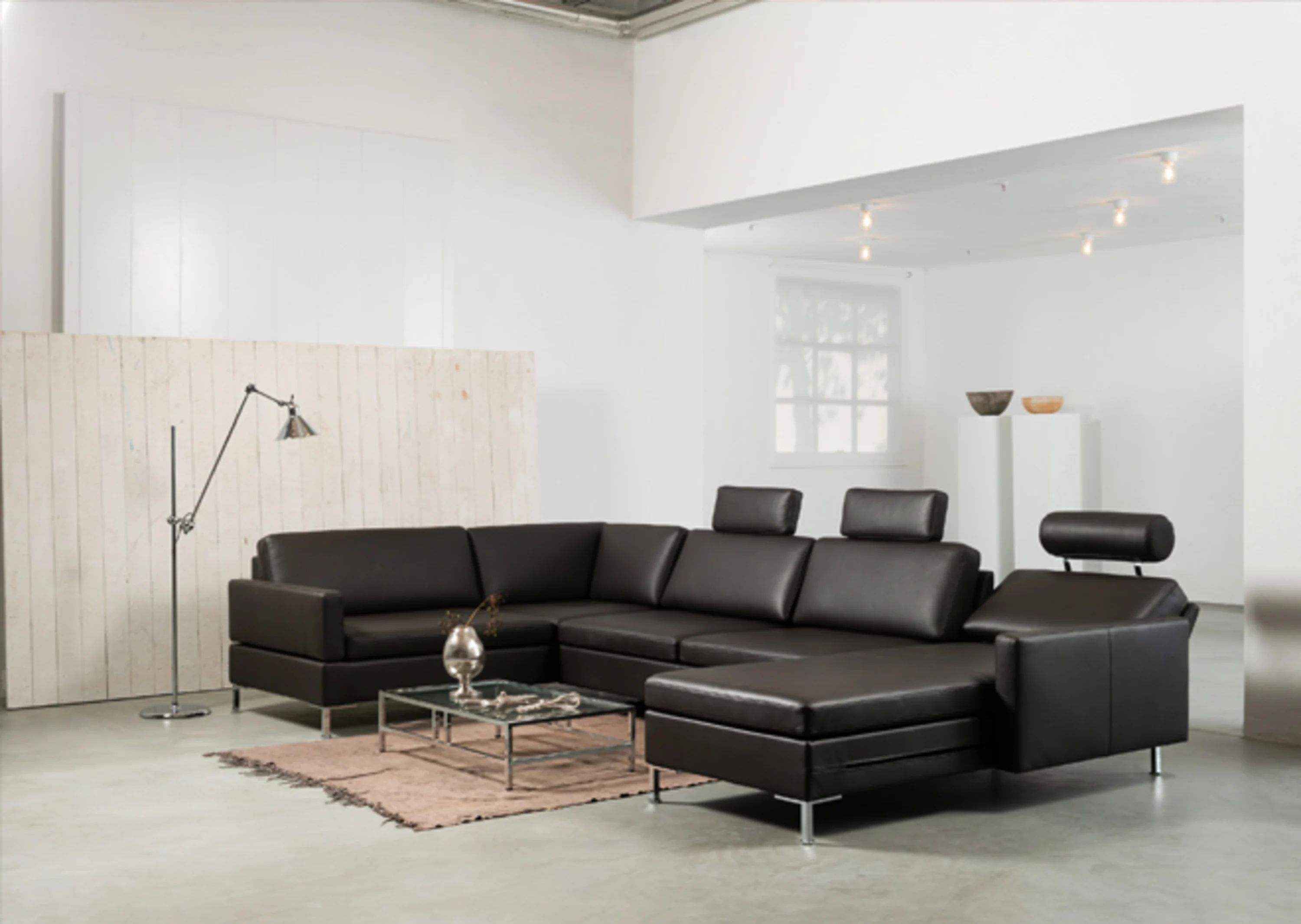 Schwarzes Leder-Sektionssofa, in einem Wohnzimmer sitzt