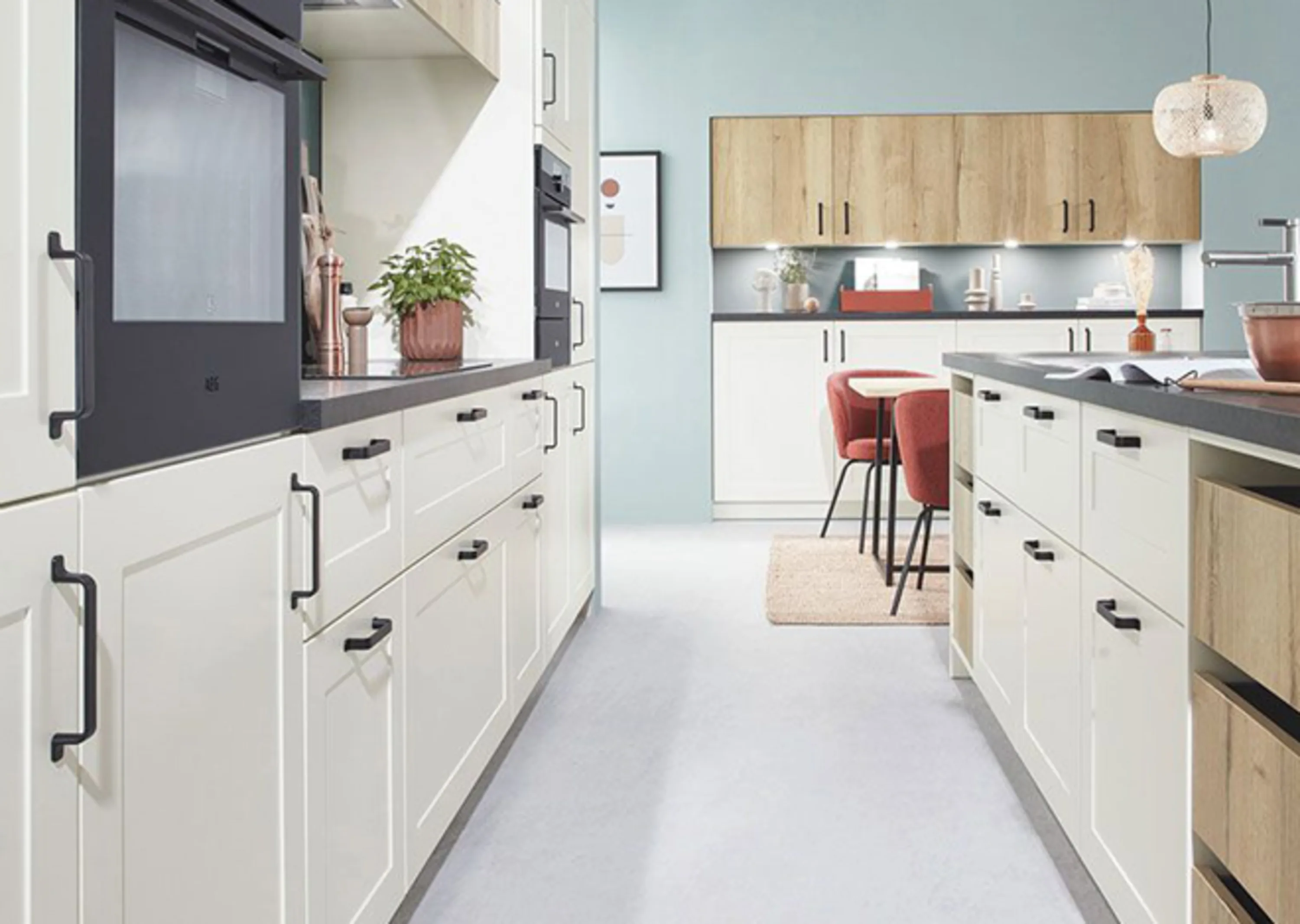 Küche mit weißen Schränken und schwarzen Counter Tops