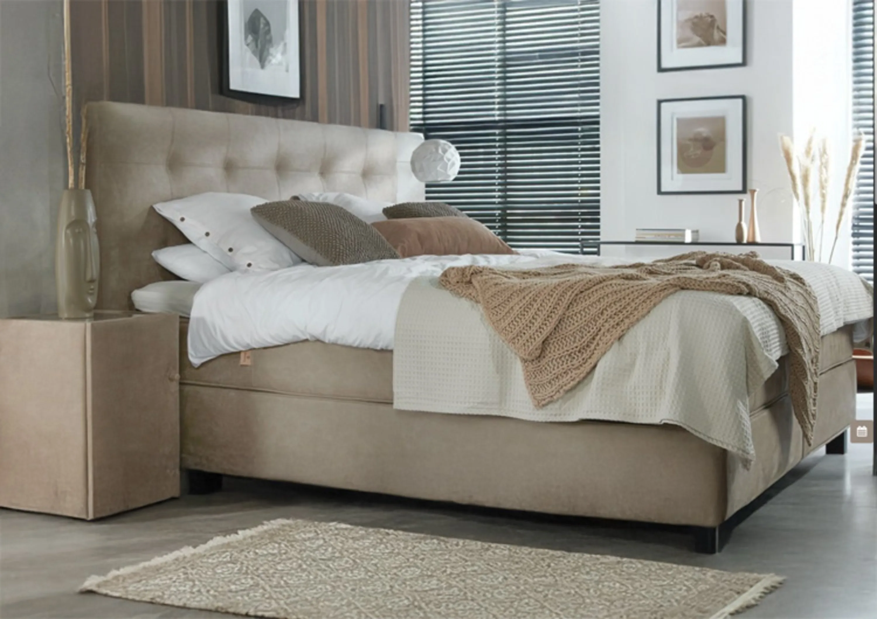 Bett mit einem beige Kopfteil und Kissen