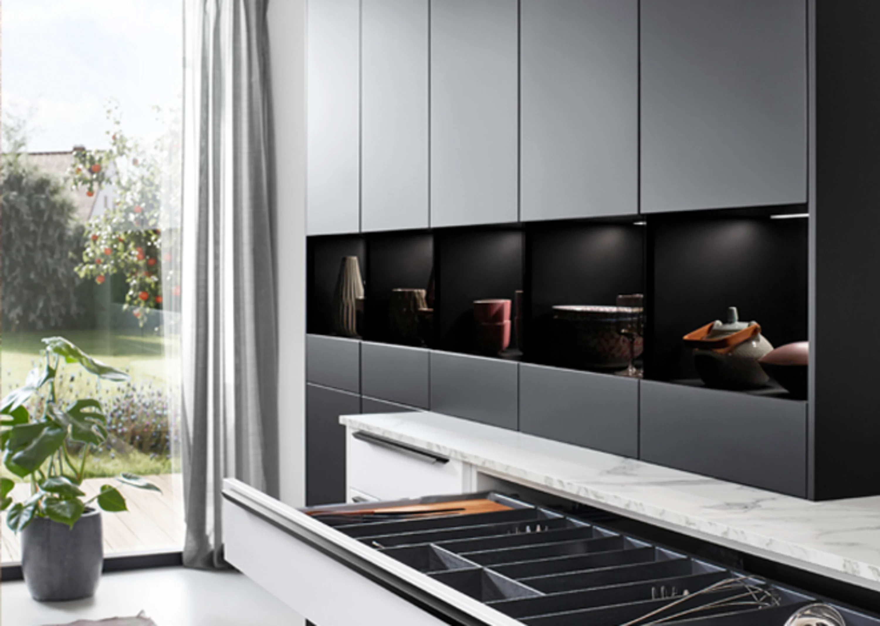 L-Küche in schwarz weiss mit Spüle in der Insel - Detailansicht Schubkästen