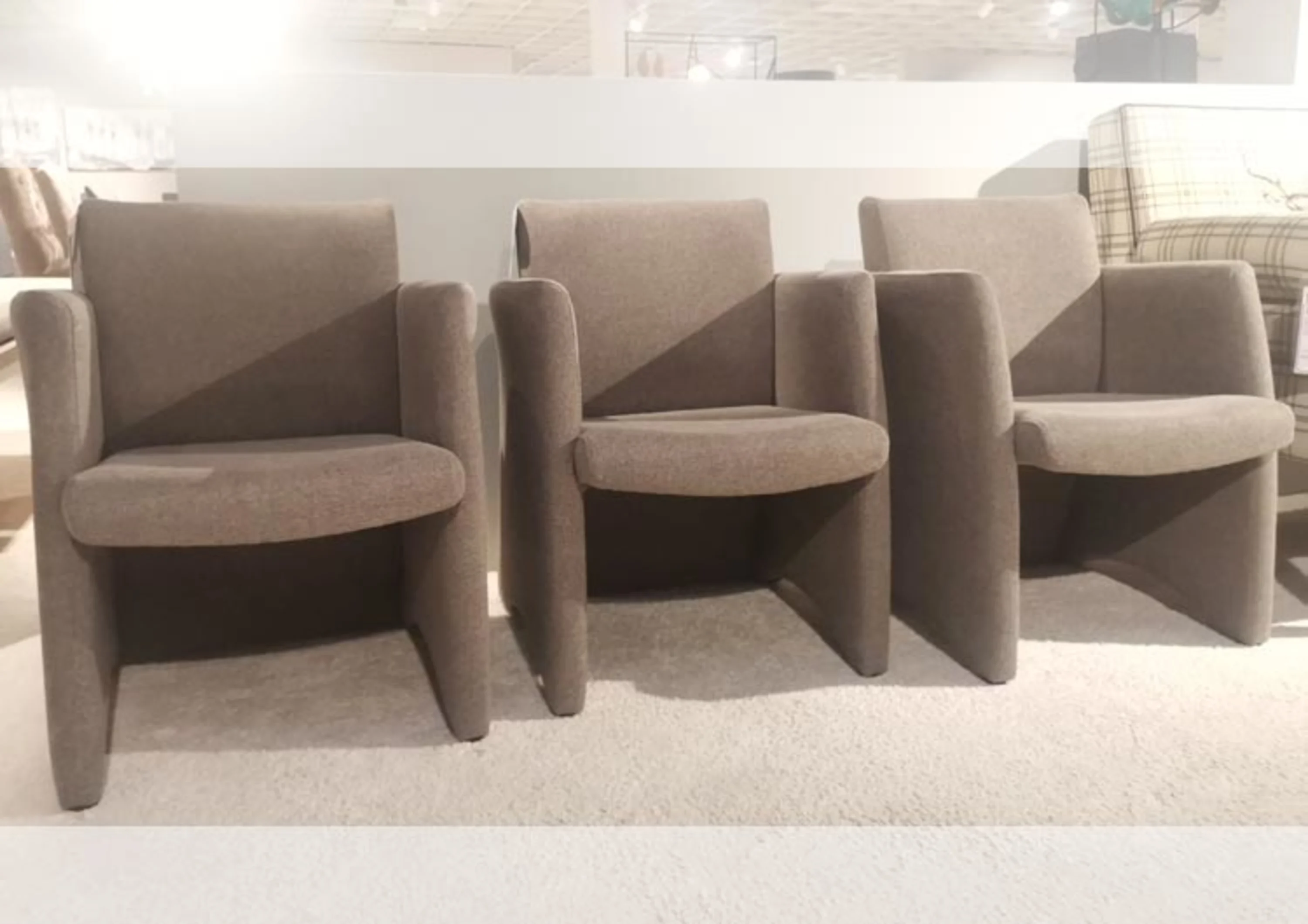 Drei Stühle in einem Raum mit einem weißen Teppich