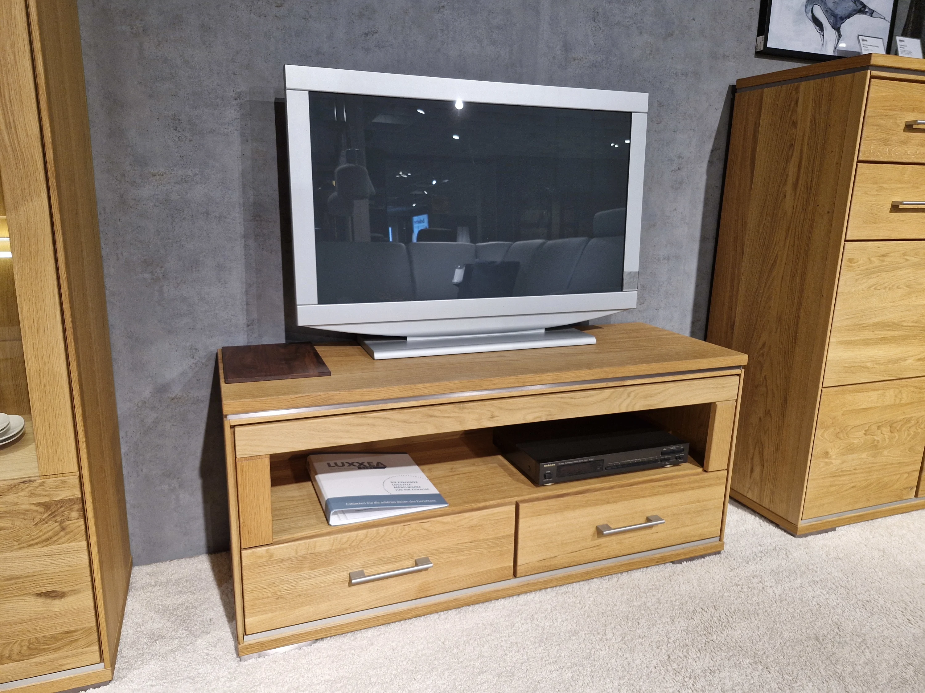 TV-Stand mit einem Flachbildschirm darauf
