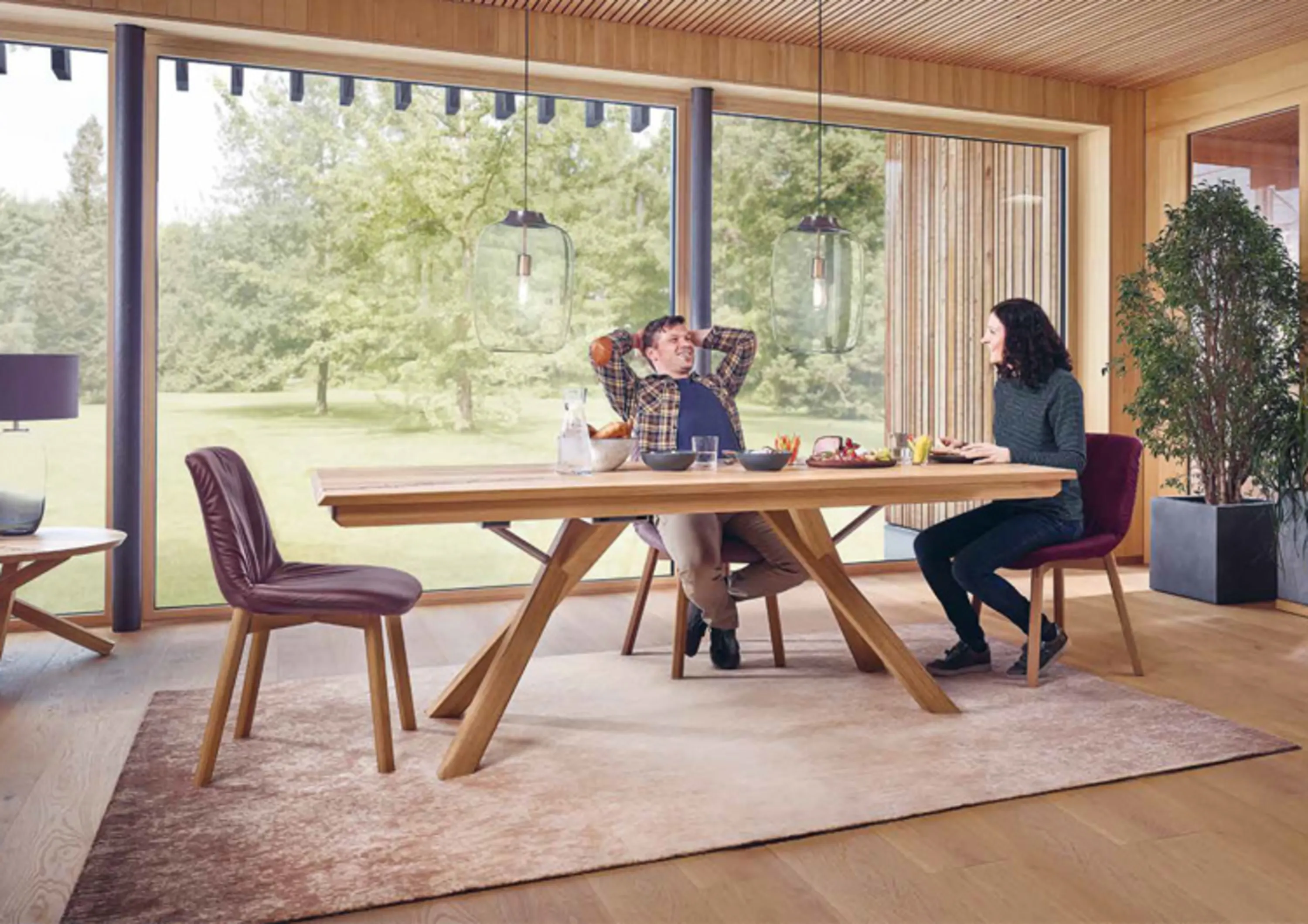 Esszimmer mit Holzesstisch darum stühle und unten drunter liegt ein großer Teppich